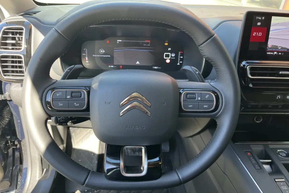 Vue rapprochée du volant cuir multifonctions et du tableau de bord numérique du Citroën C5 Aircross Bleu Eclipse 2025.
