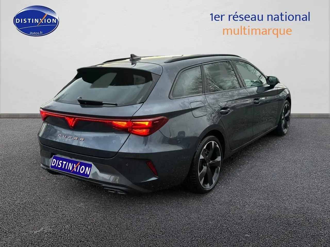 Vue 3/4 arrière droite d'une CUPRA Leon ST gris magnétique avec feux arrière LED allumés et jantes alliage.