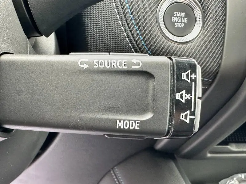 Gros plan sur la commande audio au volant du Renault Captur 2025, avec bouton Start Engine Stop et finition carbone noire.