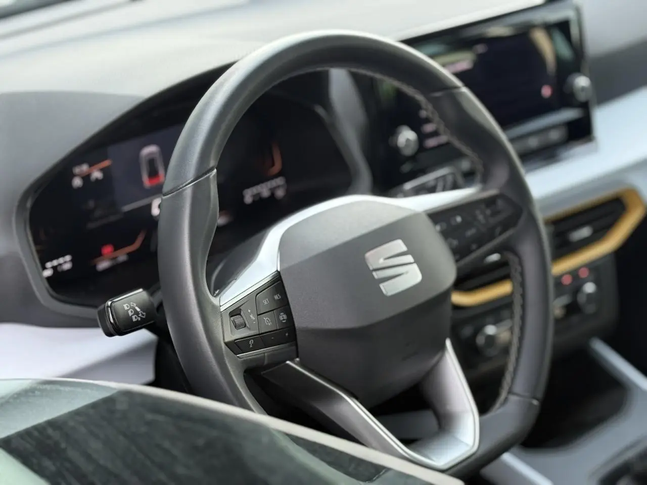 Vue rapprochée du volant noir et du tableau de bord digital du SEAT Arona TSI 115 Style 2025 avec détails modernes.