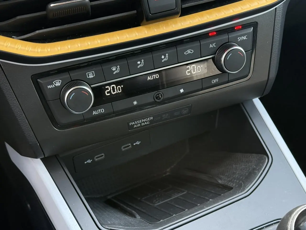 Détail de la console centrale du SEAT Arona 2025 avec commandes de climatisation bi-zone et ports USB visibles.