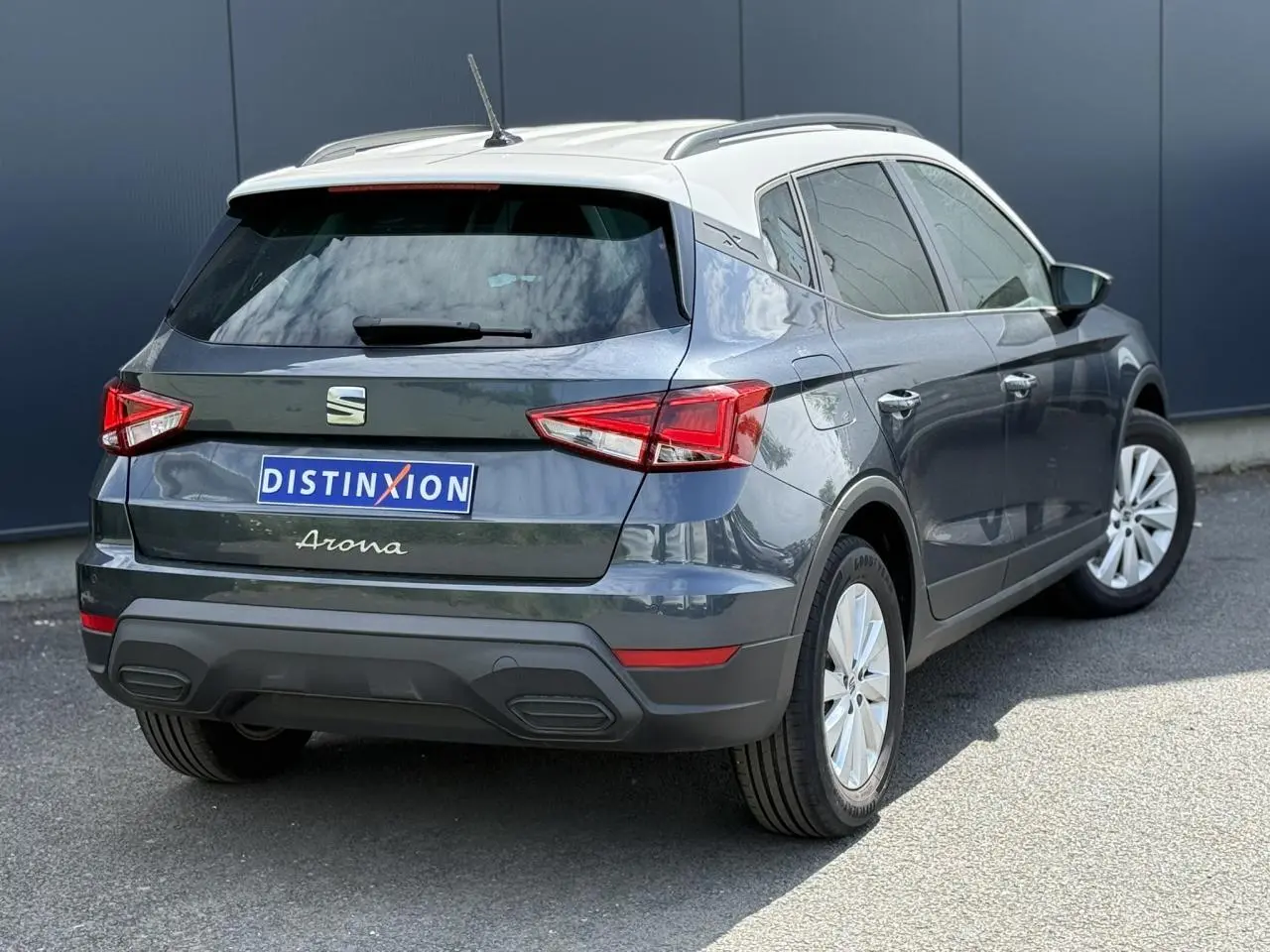 Vue 3/4 arrière droite du SEAT Arona 2025 gris magnétique avec toit blanc et vitres arrière surteintées.