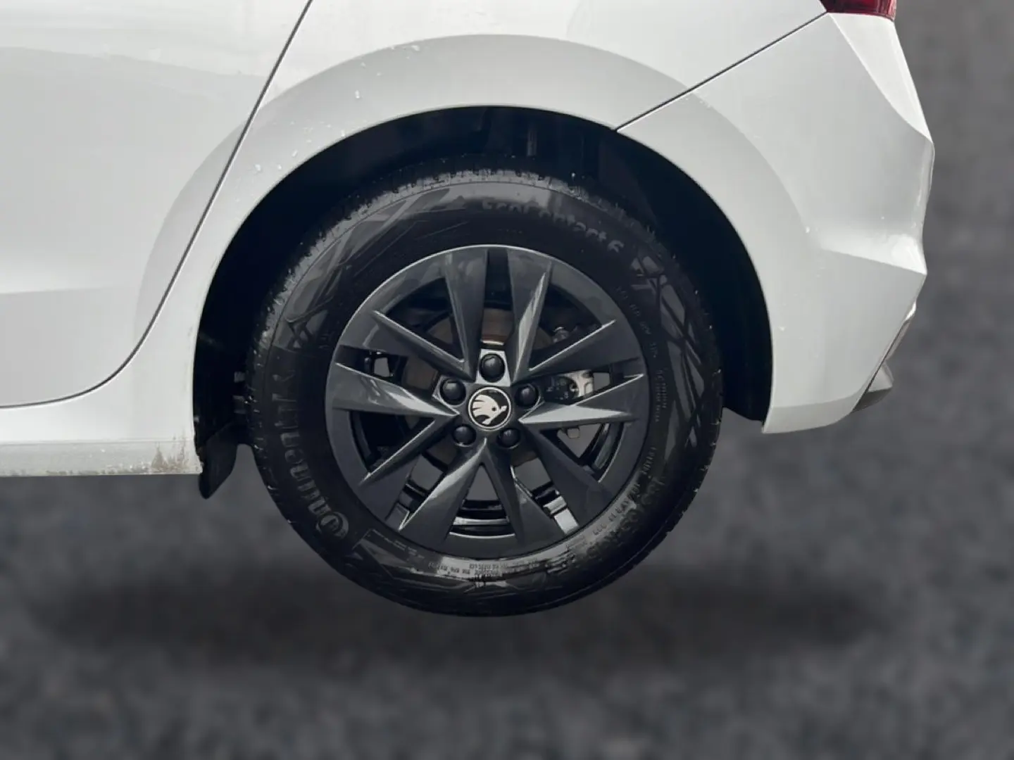 Gros plan sur la roue arrière droite noire avec jante alu d’une Skoda Fabia blanche de 2025.