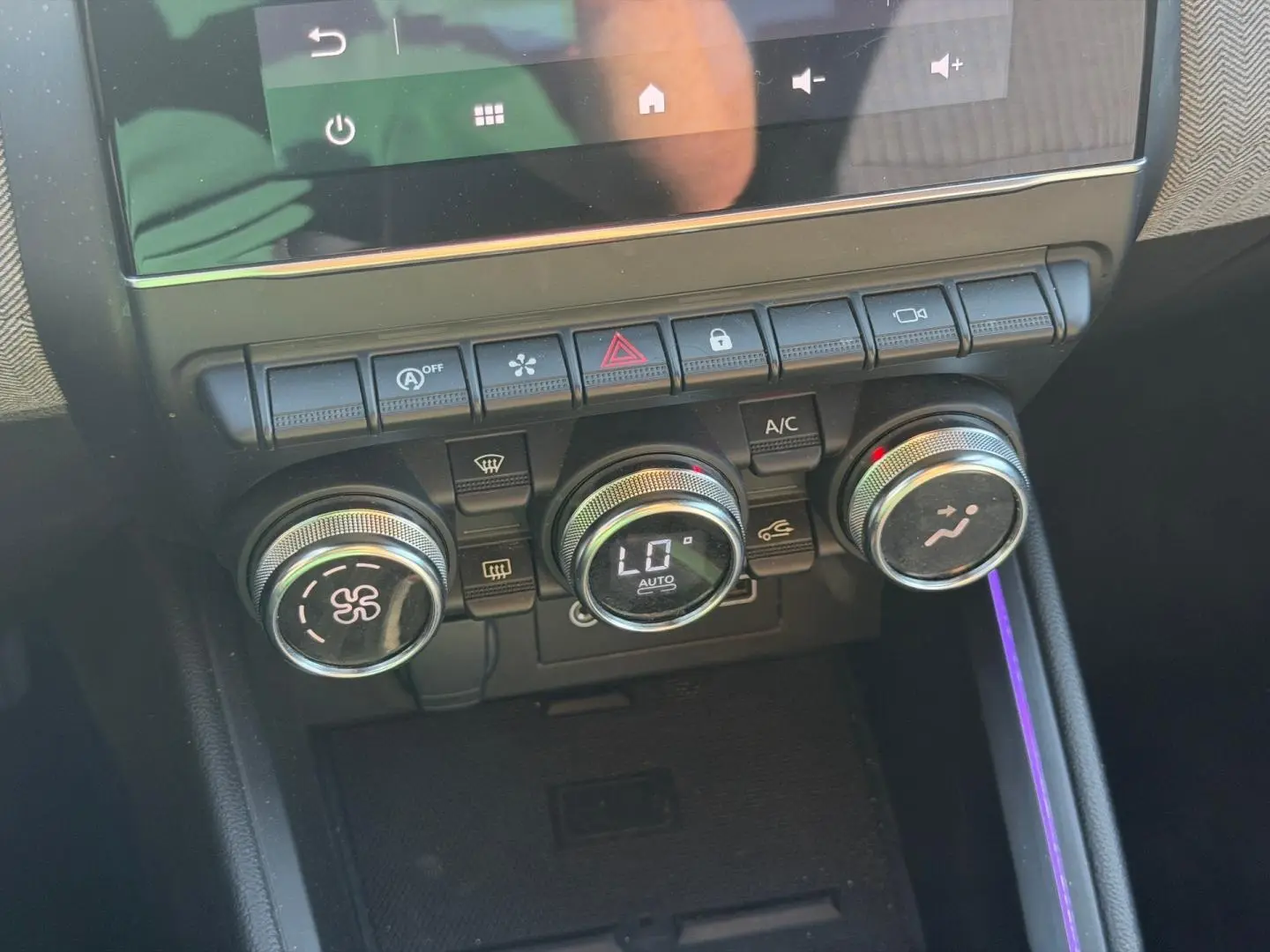 Gros plan sur les commandes de climatisation avec éclairage d’ambiance violet dans l’habitacle d’une Renault Clio 2025.