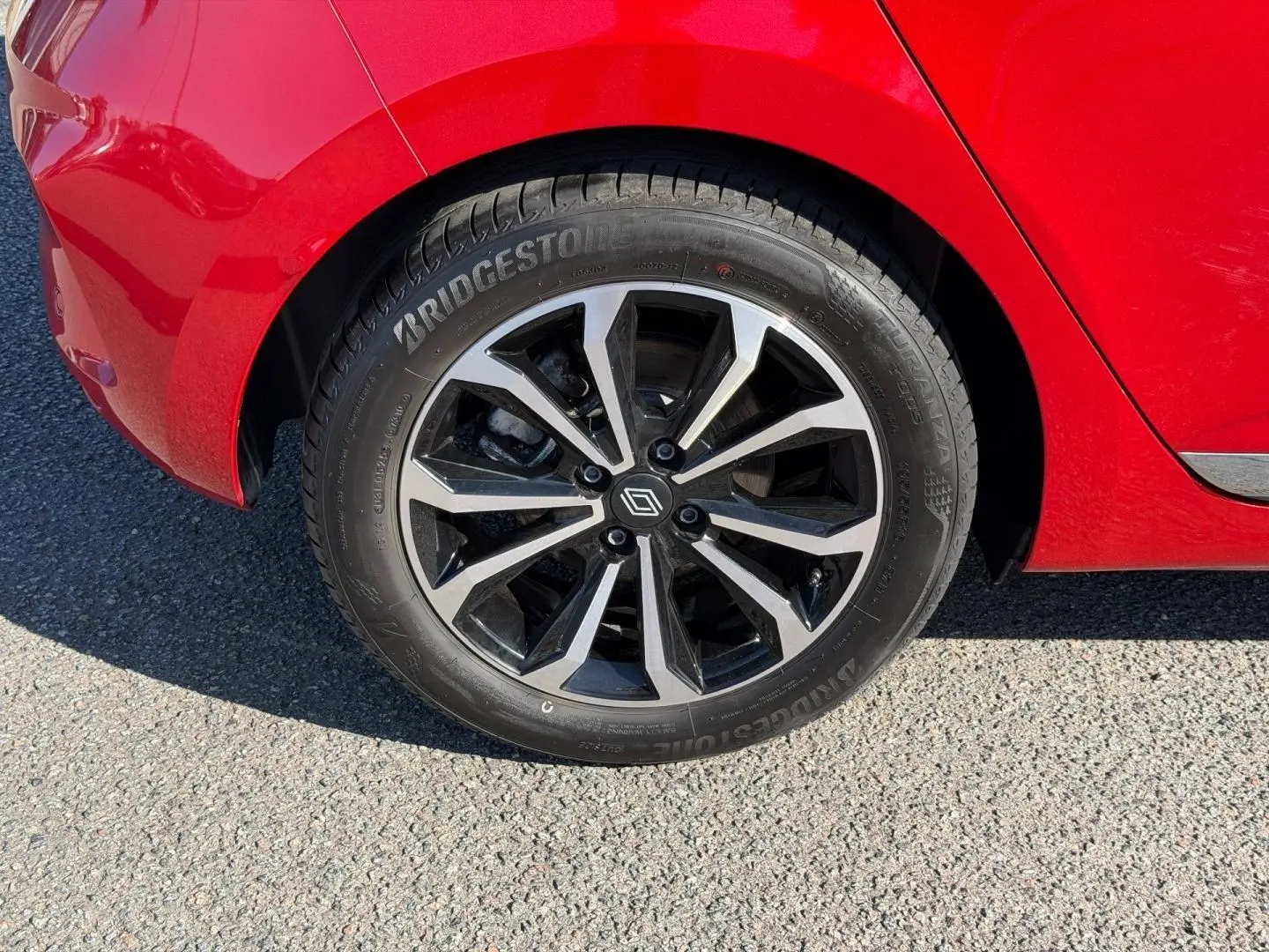 Gros plan sur la roue arrière droite orange de la Renault Clio 2025 avec jante alliage noire et argentée.