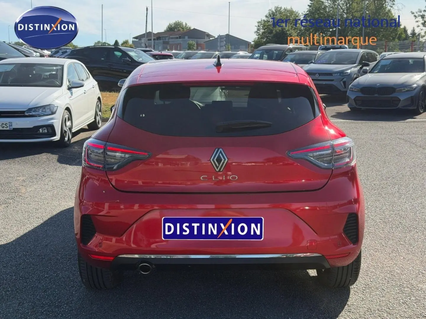 Vue arrière d'une Renault Clio orange Valencia 2025 avec feux LED et sortie d'échappement chromée visible.