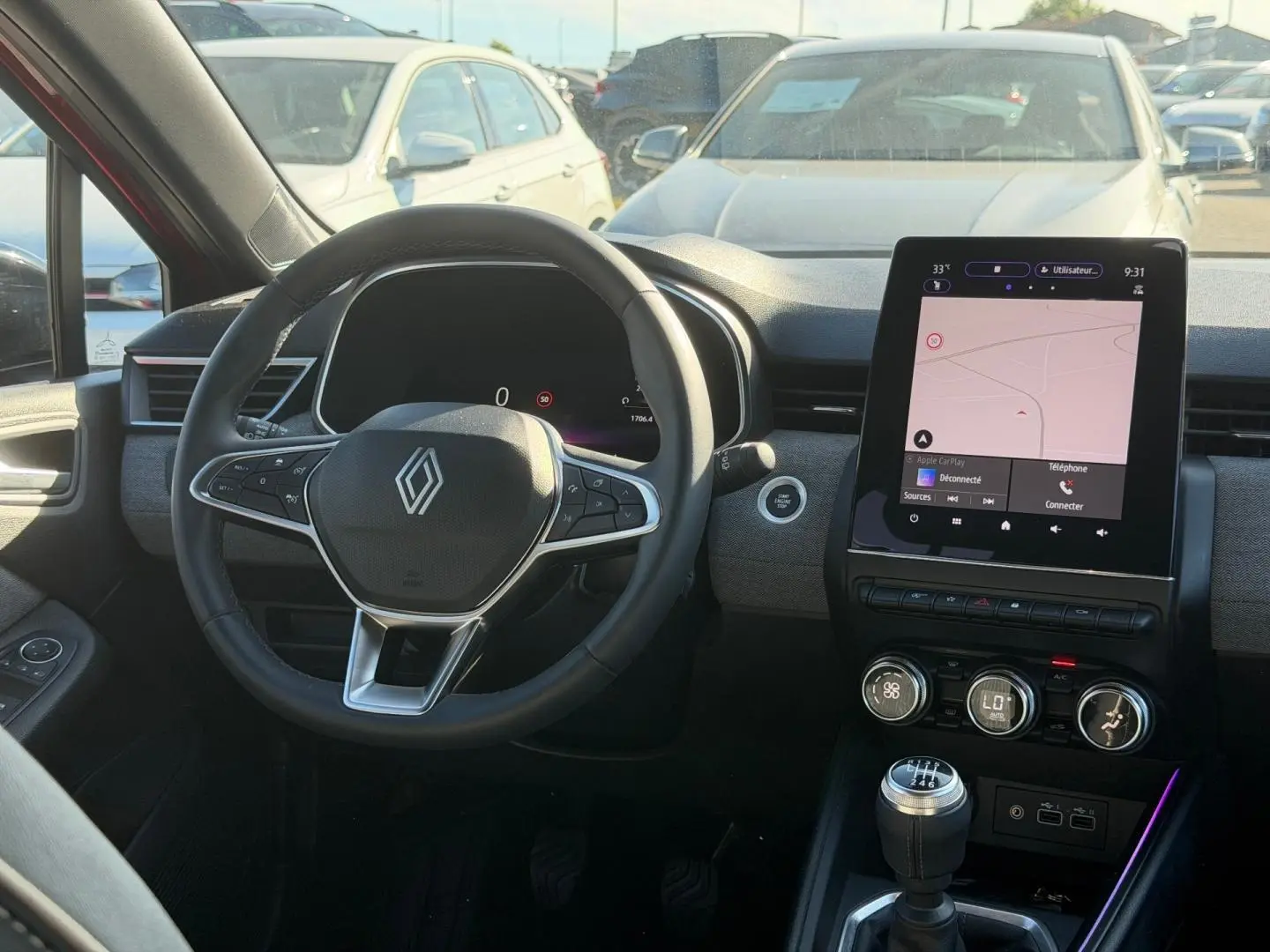 Intérieur de la Renault Clio 2025 vu de face, volant multifonction, écran tactile central et levier de vitesses manuel.