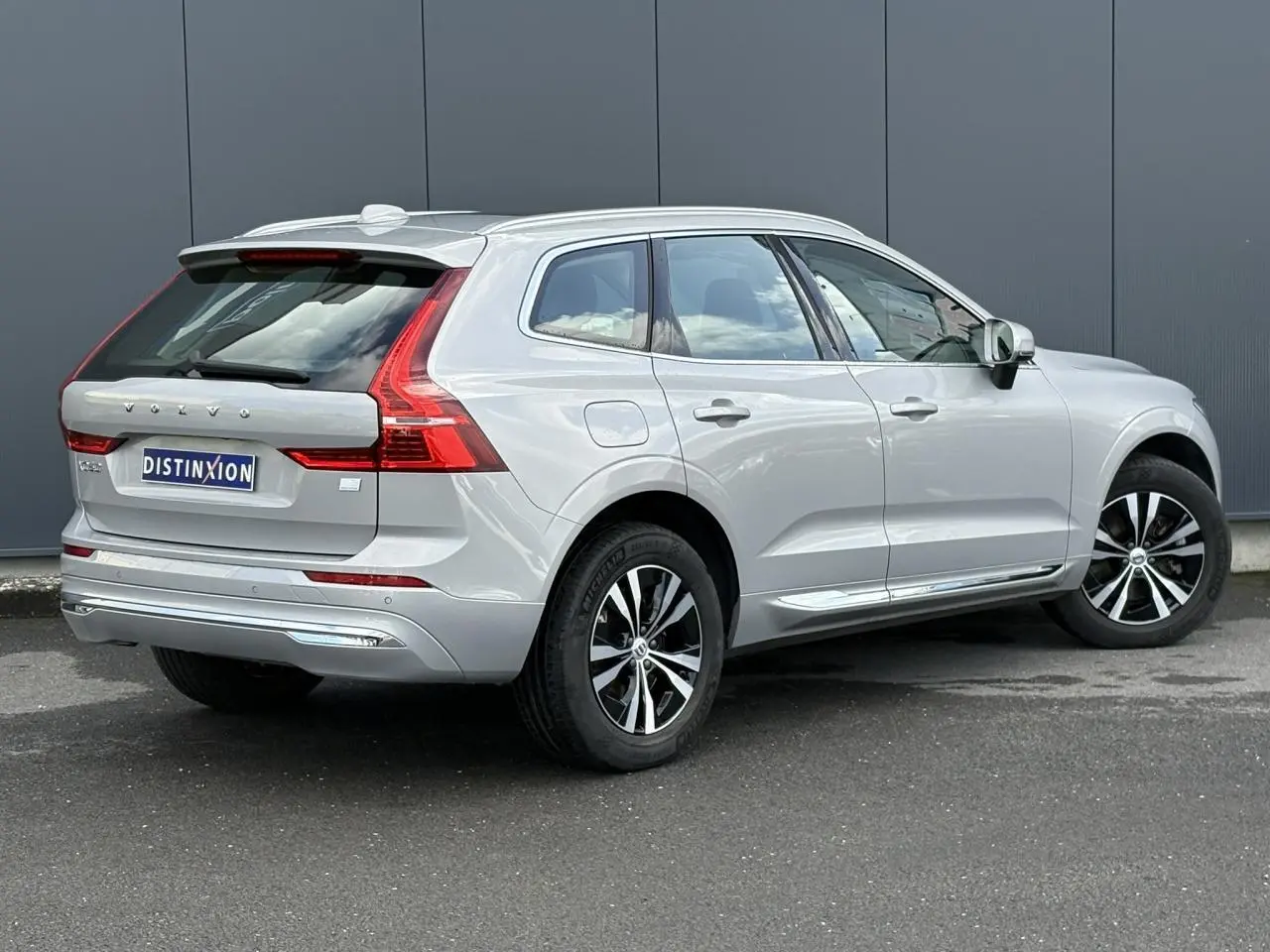 Vue 3/4 arrière droite d'un Volvo XC60 gris silver avec jantes alliage et feux arrière LED distinctifs.