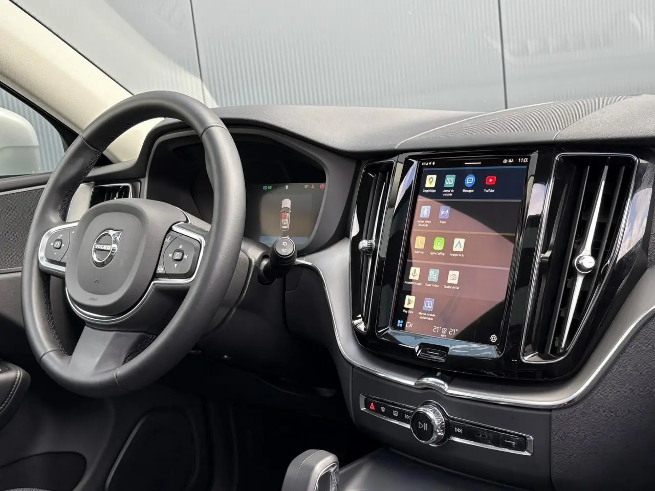 Intérieur du Volvo XC60 T6 AWD PHEV 2024, vue du tableau de bord et volant simili-cuir noir avec écran tactile central.