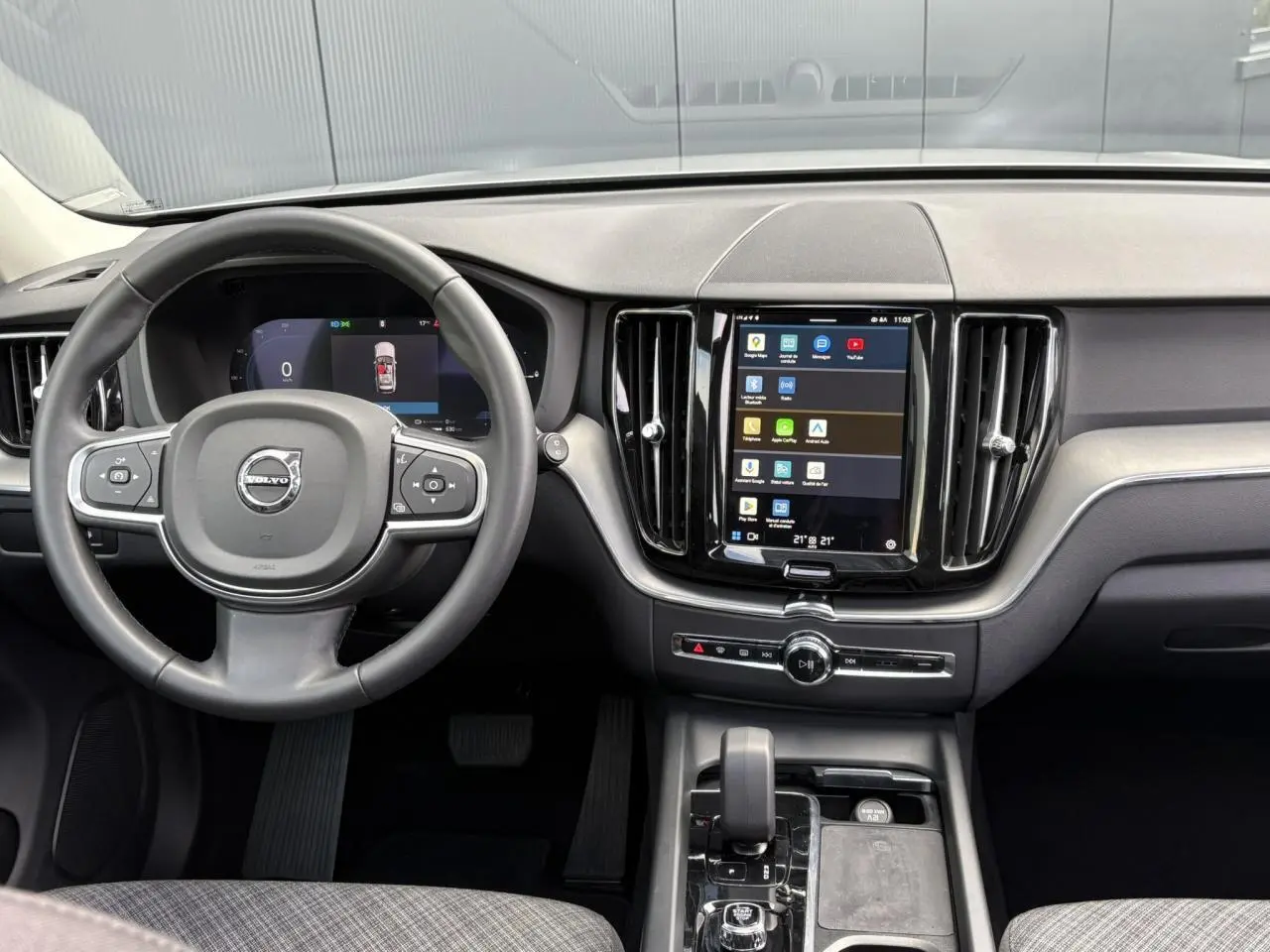 Intérieur du Volvo XC60 T6 AWD PHEV 2024 montrant le tableau de bord noir avec écran tactile vertical et volant simili-cuir.