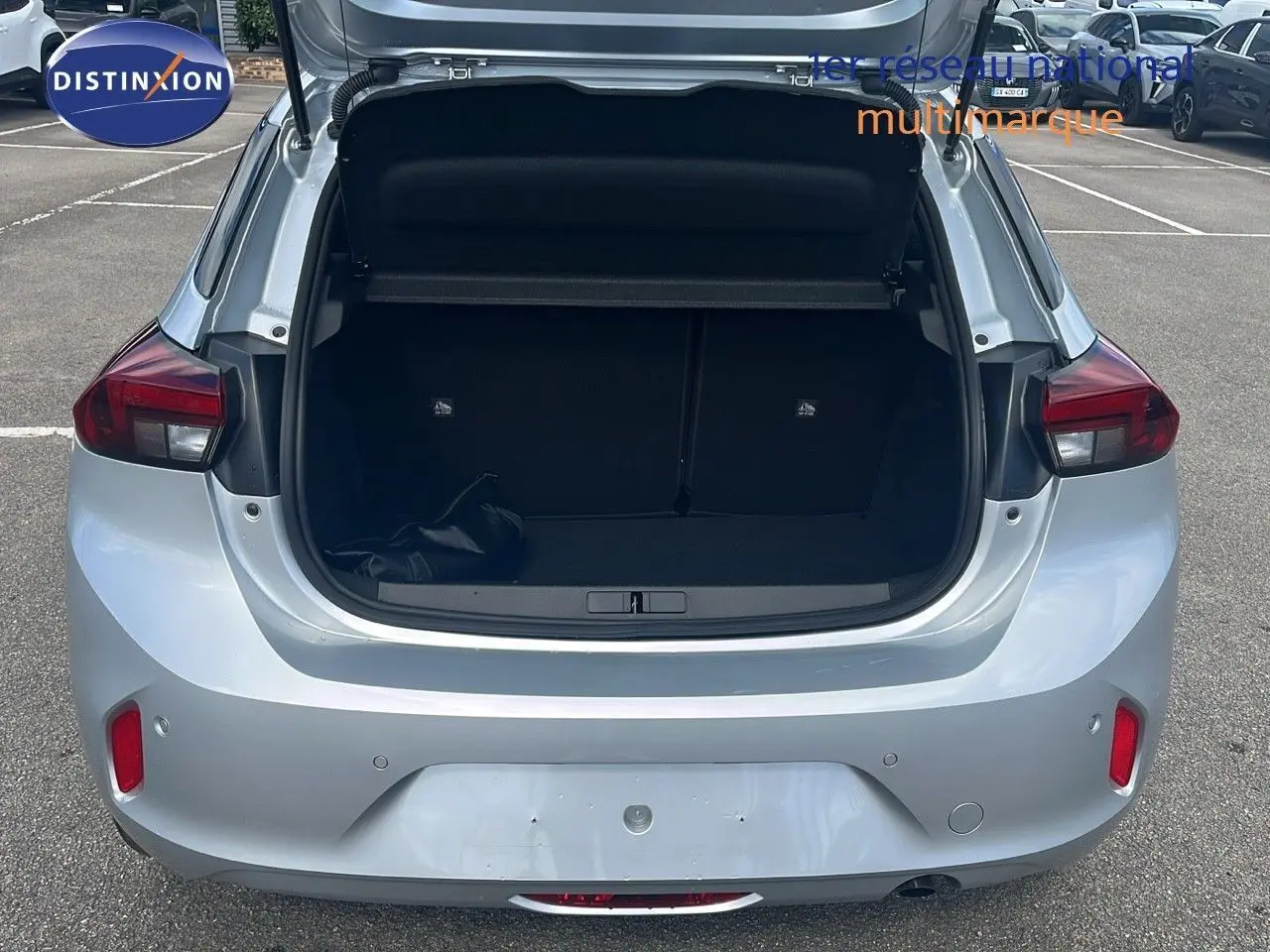 Vue arrière d'une Opel Corsa gris kristal métal 2025 avec coffre ouvert montrant l'espace de chargement vide.
