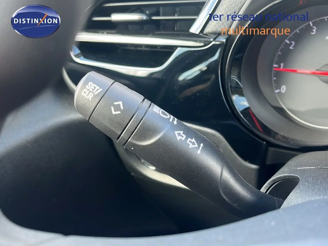 Gros plan sur la manette de clignotant à gauche du tableau de bord d'une Opel Corsa gris kristal métal 2025.