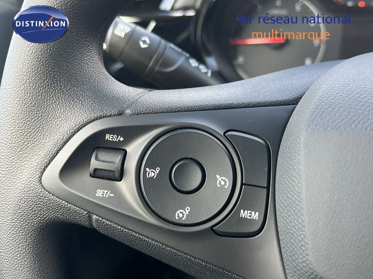 Gros plan sur les commandes de régulateur de vitesse au volant d'une Opel Corsa gris Kristal Metal de 2025.