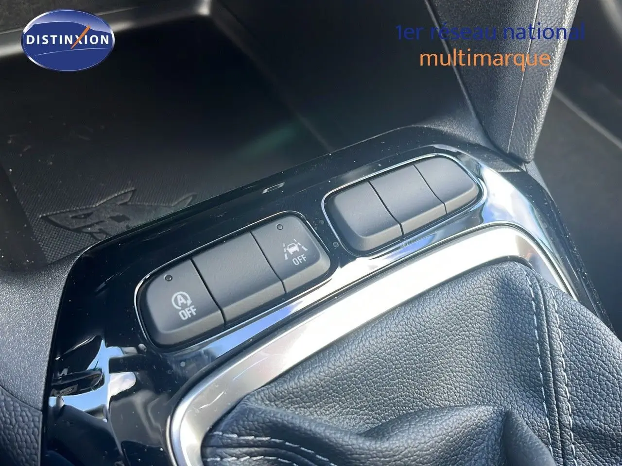 Gros plan sur la console centrale de l'Opel Corsa 2025, montrant les boutons de contrôle et le soufflet de levier de vitesse en cuir noir.