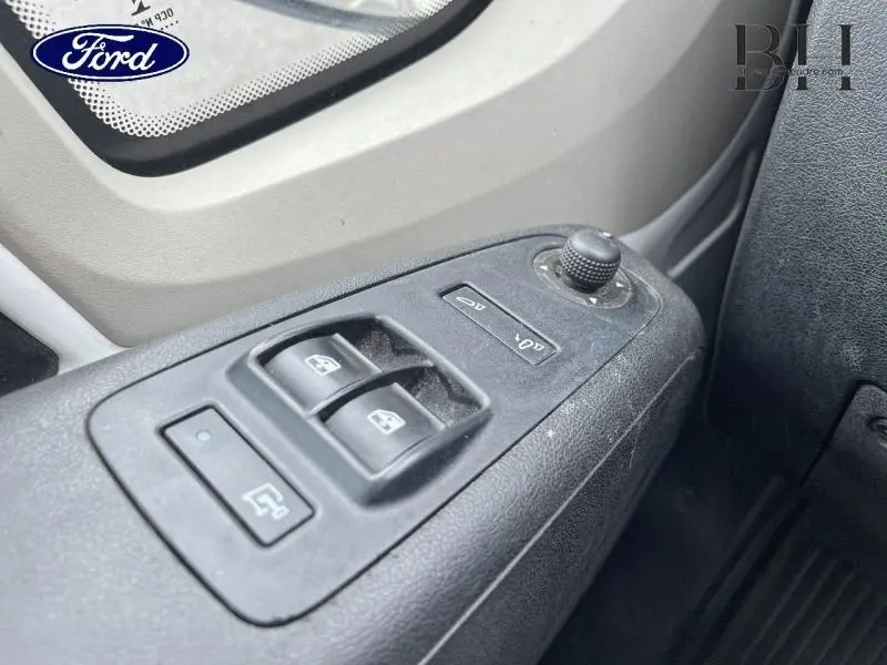 Gros plan sur les commandes des vitres électriques côté gauche d'un Citroën Jumper blanc, avec réglage des rétroviseurs.