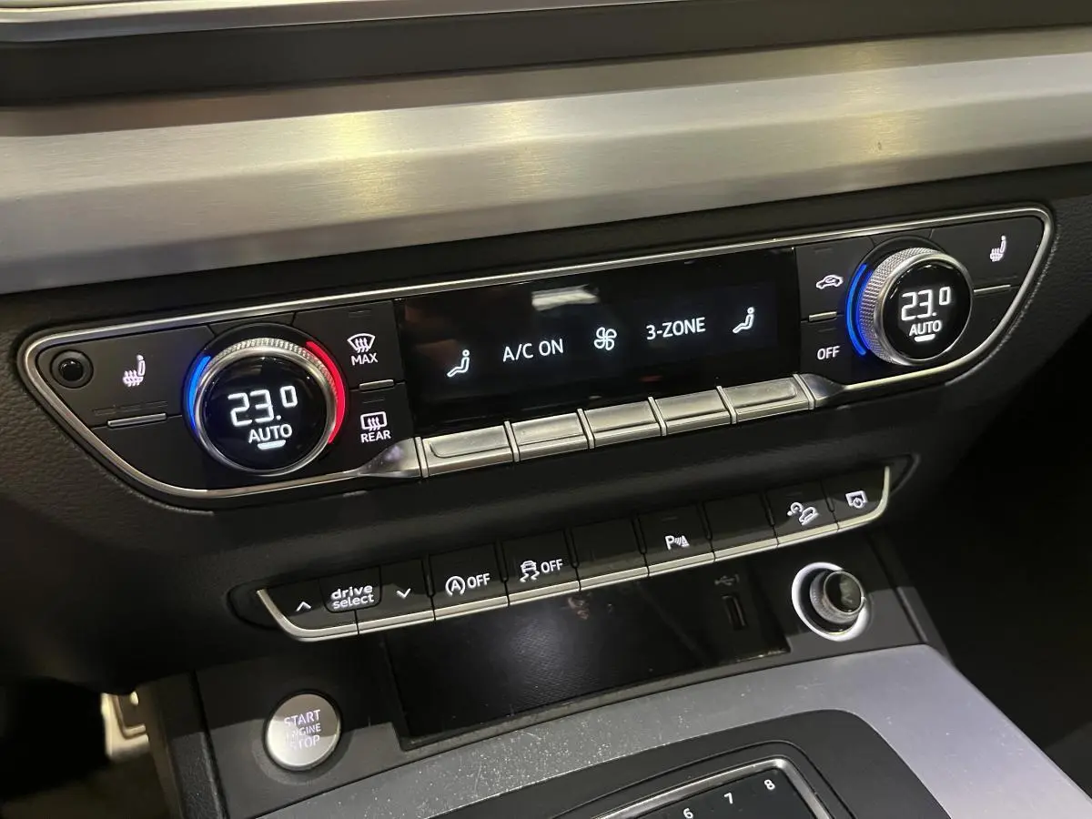 Console centrale de l'Audi Q5 S line 2019 montrant la climatisation automatique 3 zones et commandes multifonctions.
