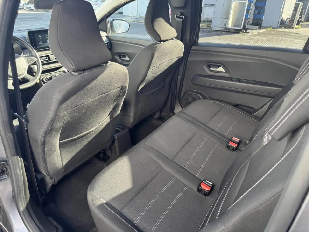 Vue intérieure côté droit sur la banquette arrière noire et les sièges avant du Dacia Jogger gris schiste 2025.