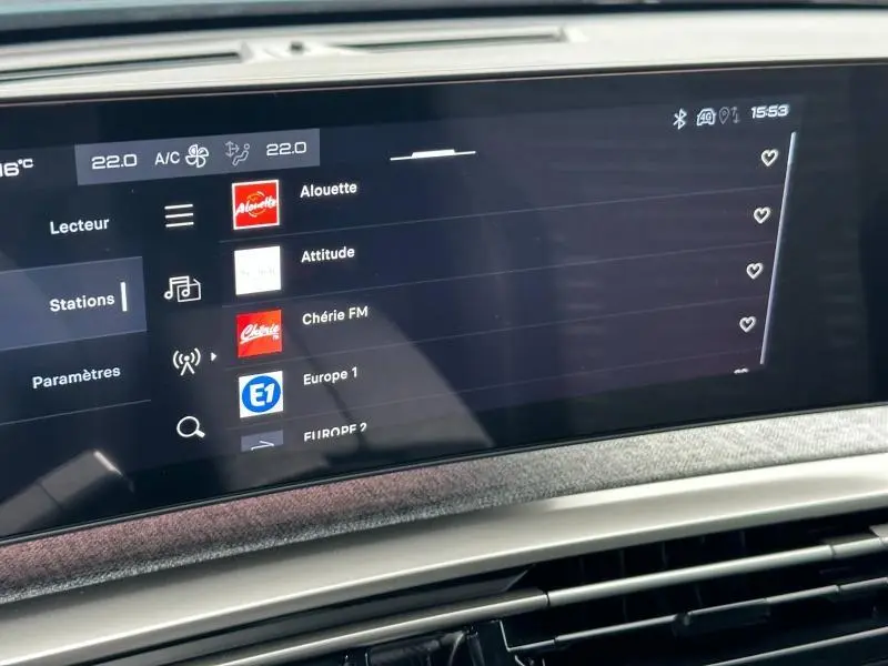 Écran tactile central du Peugeot 3008 Hybrid 2025 affichant les stations radio avec interface moderne et finition tissu gris.