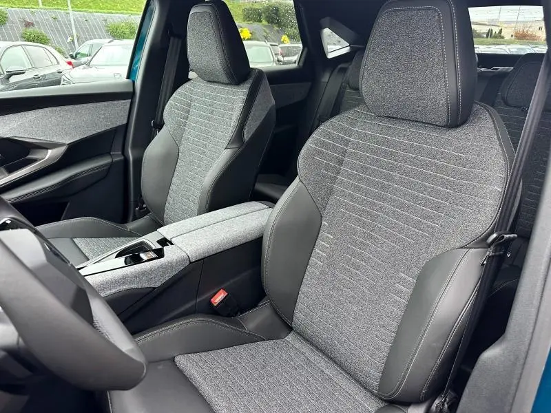 Vue intérieure des sièges avant gris tissu CRISPY et cuir noir du Peugeot 3008 bleu 2025 côté conducteur et passager.