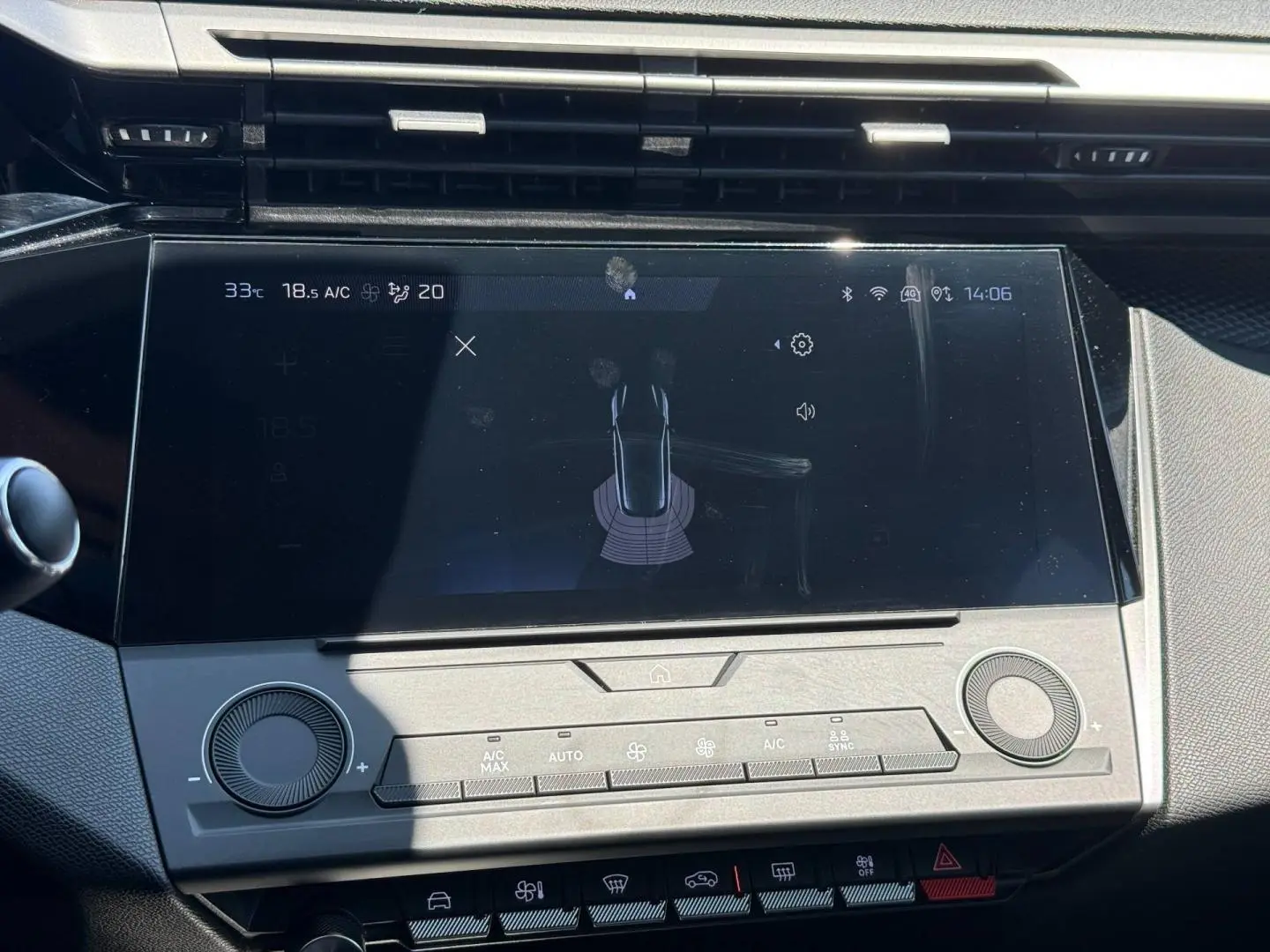 Vue rapprochée de l’écran tactile central de la Peugeot e-308 2025 avec commandes climatisation et interface multimédia.