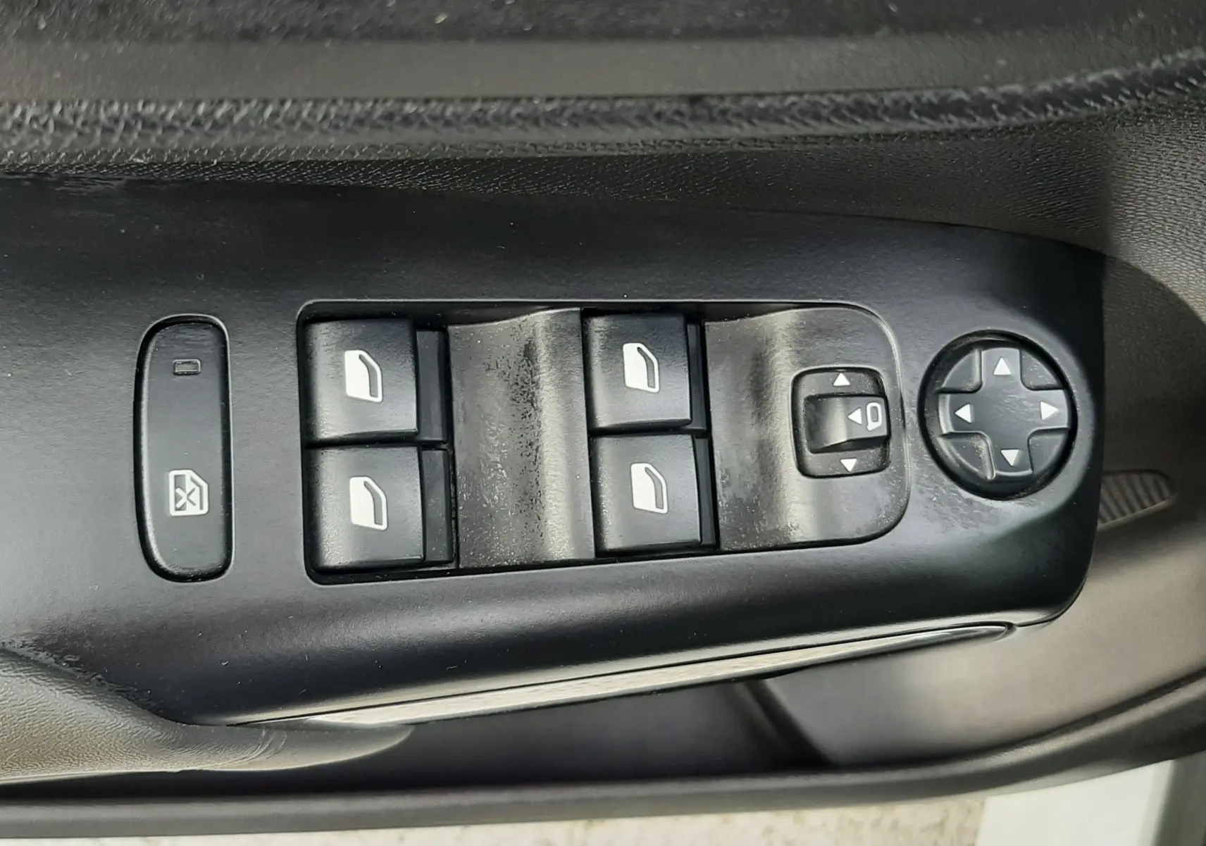 Vue rapprochée des commandes de lève-vitres et réglage des rétroviseurs sur la porte côté conducteur d’un Citroën C5 Aircross blanc.