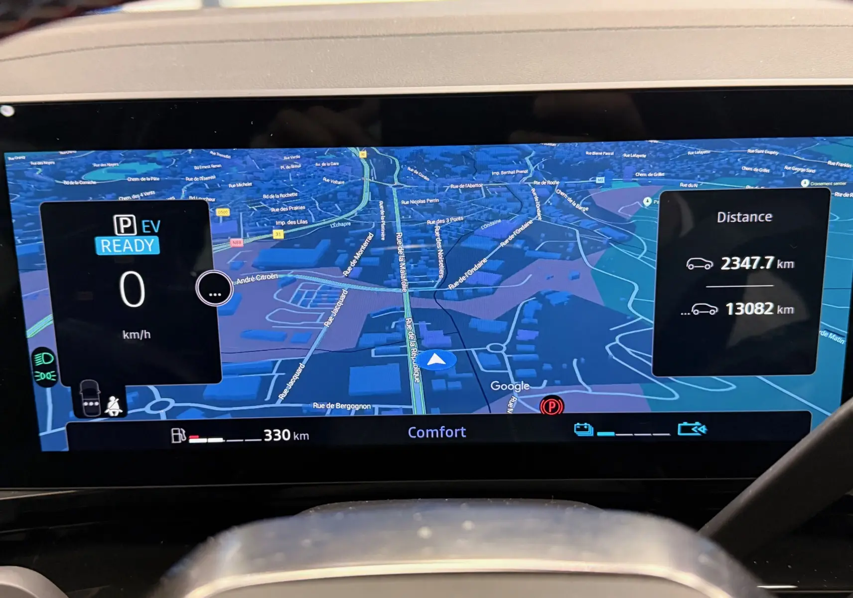 Affichage numérique du tableau de bord du Renault Austral E-Tech hybride, montrant la navigation et les distances parcourues.