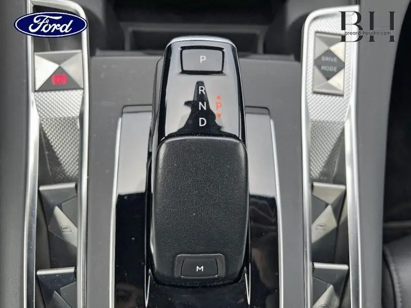 Gros plan sur la commande de boîte automatique noire brillante du DS7 BlueHDi 130ch Opera, avec boutons de mode et frein à main.