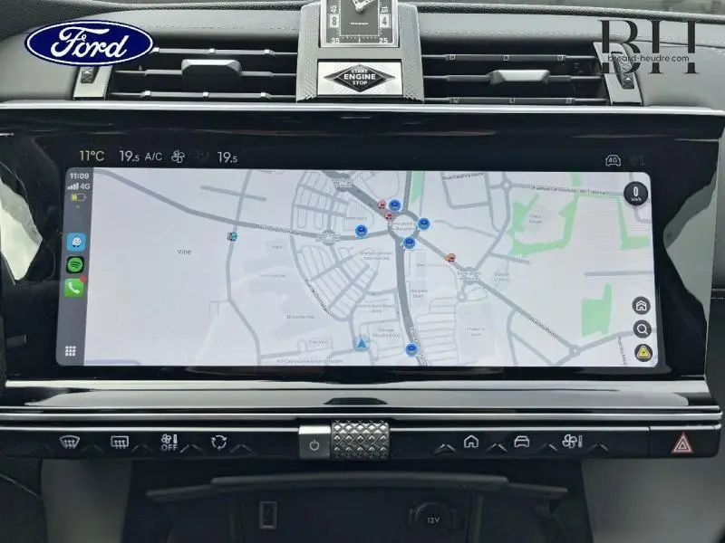 Vue intérieure centrée sur l'écran tactile du GPS du DS7 Gris Laqué avec horloge et commandes intégrées au tableau de bord.