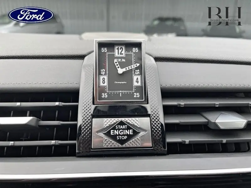 Gros plan sur l'horloge analogique et le bouton Start Engine Stop du tableau de bord gris laqué du DS7 2023.