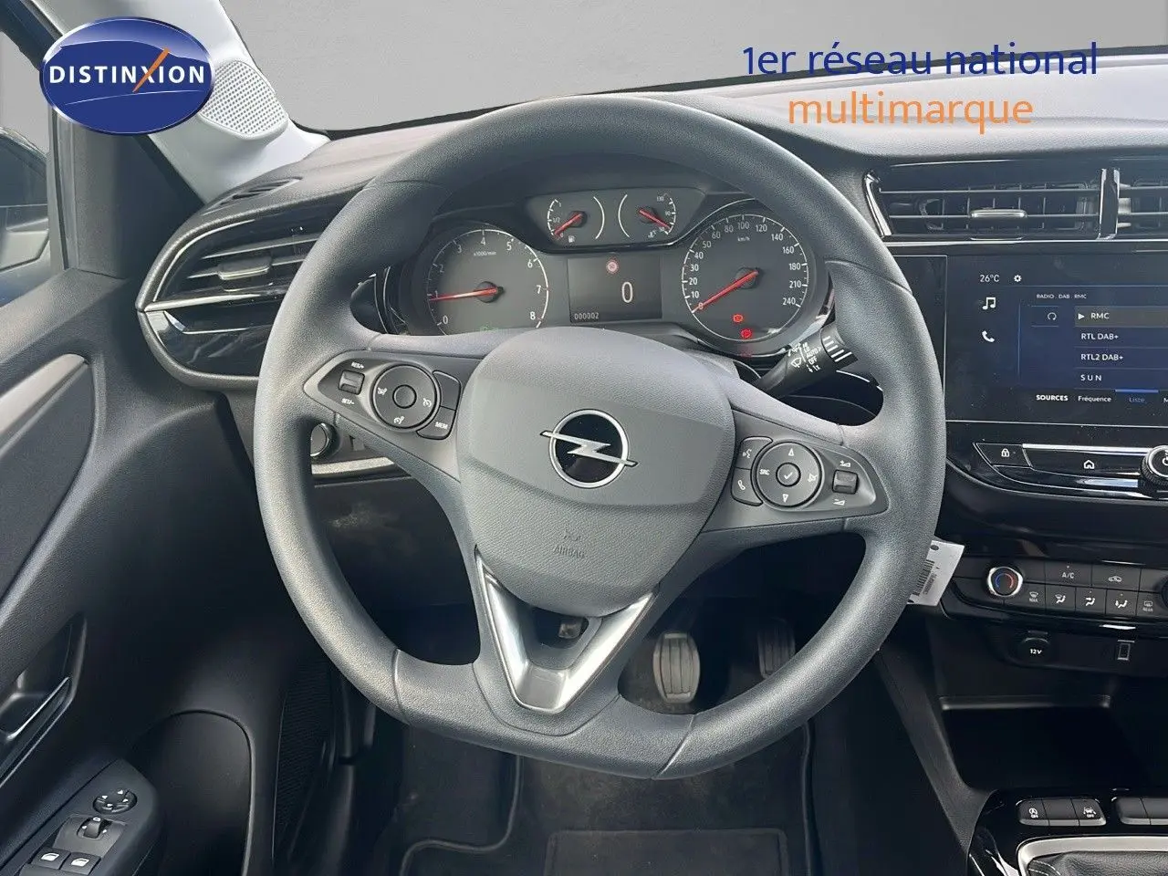 Vue intérieure centrée sur le volant Opel d'une Corsa 2025, avec tableau de bord et écran tactile visibles.