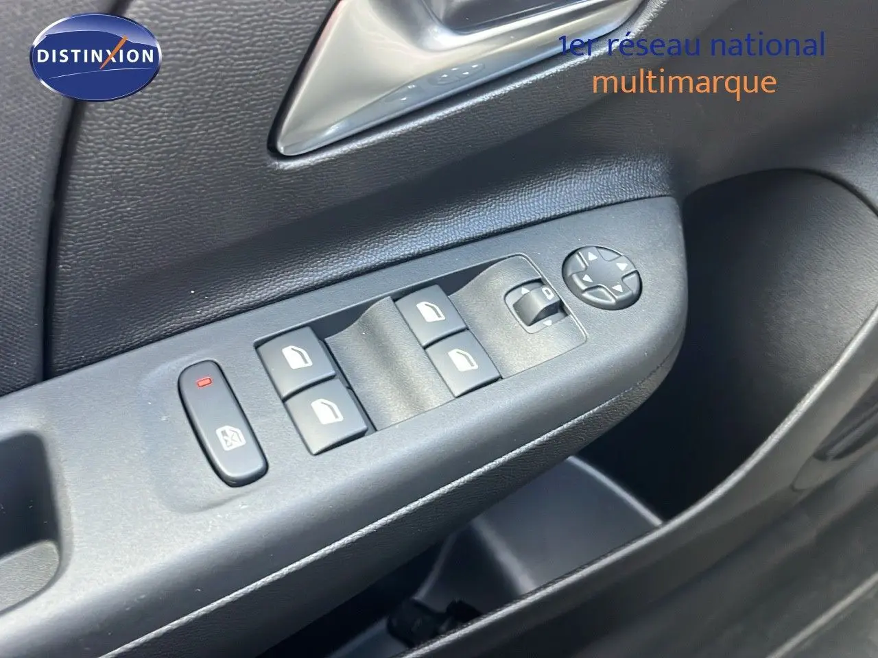 Gros plan sur la commande des vitres électriques côté conducteur de l'Opel Corsa bleu Voltaik métal, finition 2025.