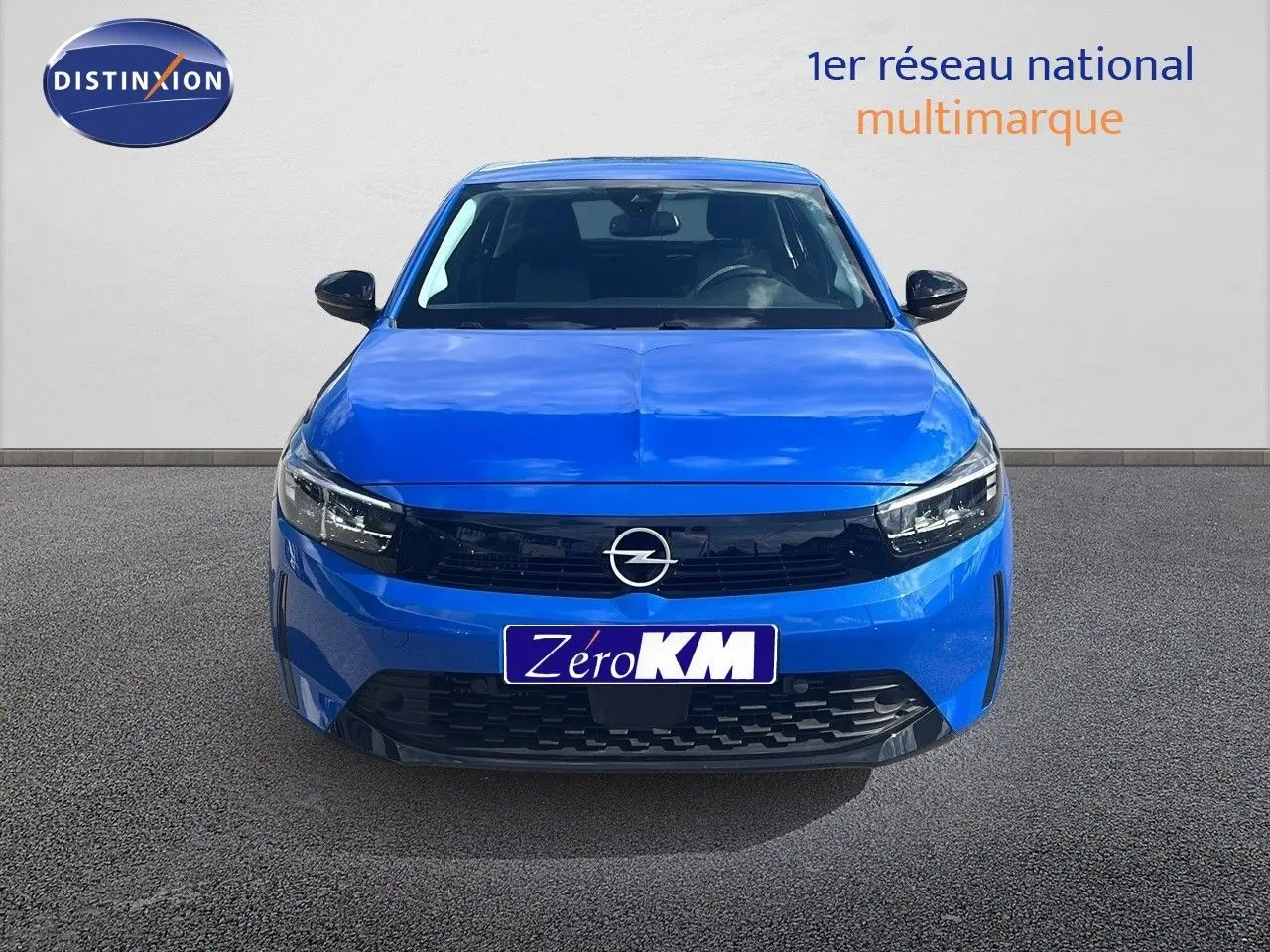 Vue frontale d'une Opel Corsa 2025 bleu voltaik métal avec calandre noire et phares LED allumés.