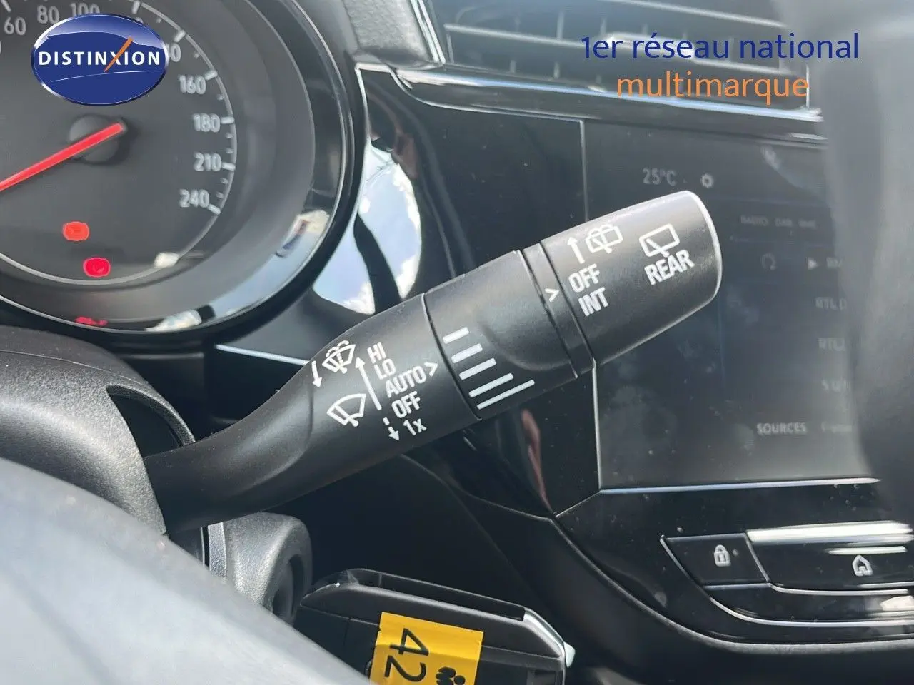 Gros plan sur la commande des essuie-glaces à gauche du volant dans l'habitacle d'une Opel Corsa bleu Voltaik Metal 2025.