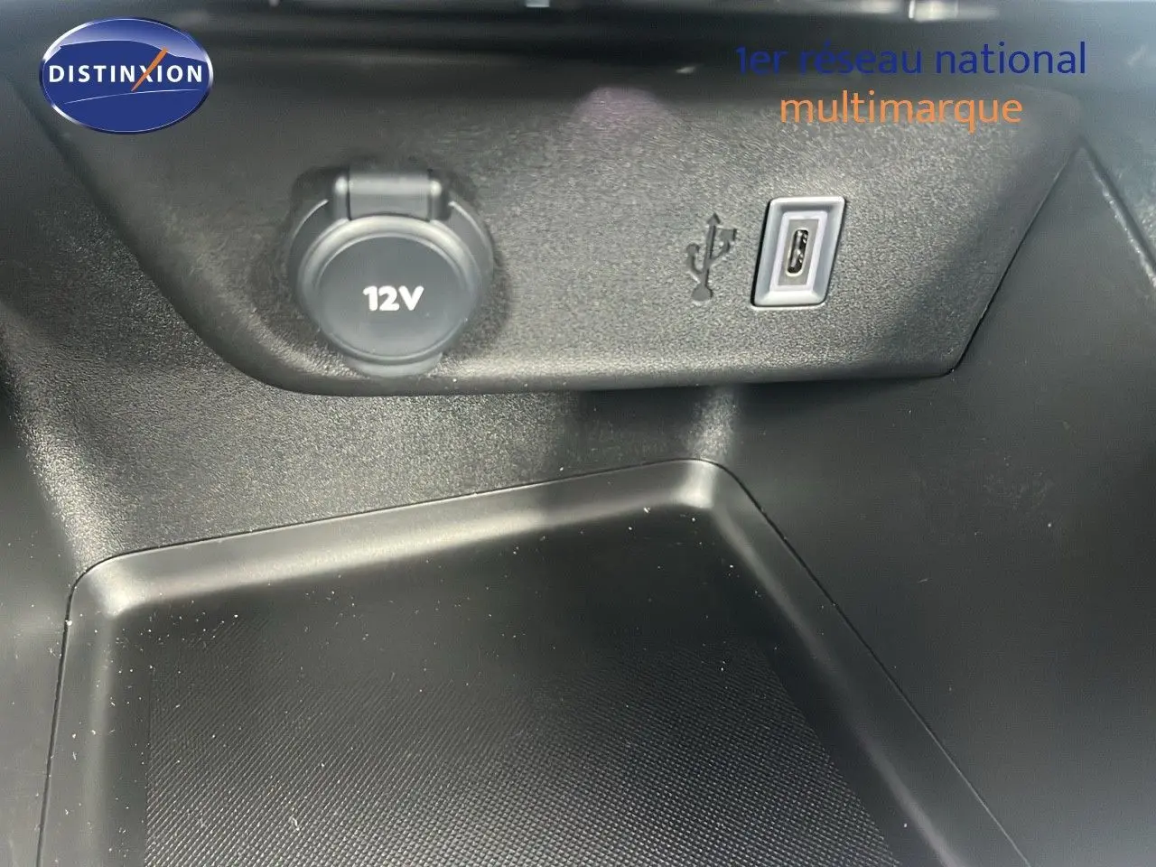 Prise 12V et port USB en gros plan dans l'habitacle de l'Opel Corsa bleu Voltaik Metal, version 2025.