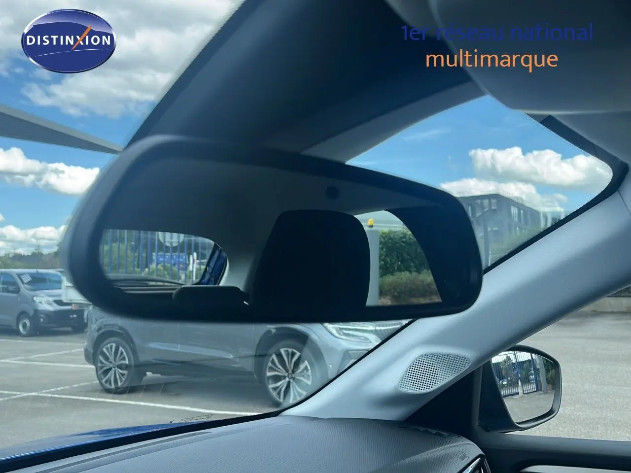 Intérieur de l’Opel Corsa bleu voltaik métal 2025 vu côté conducteur avec rétroviseur et vitre latérale visibles.