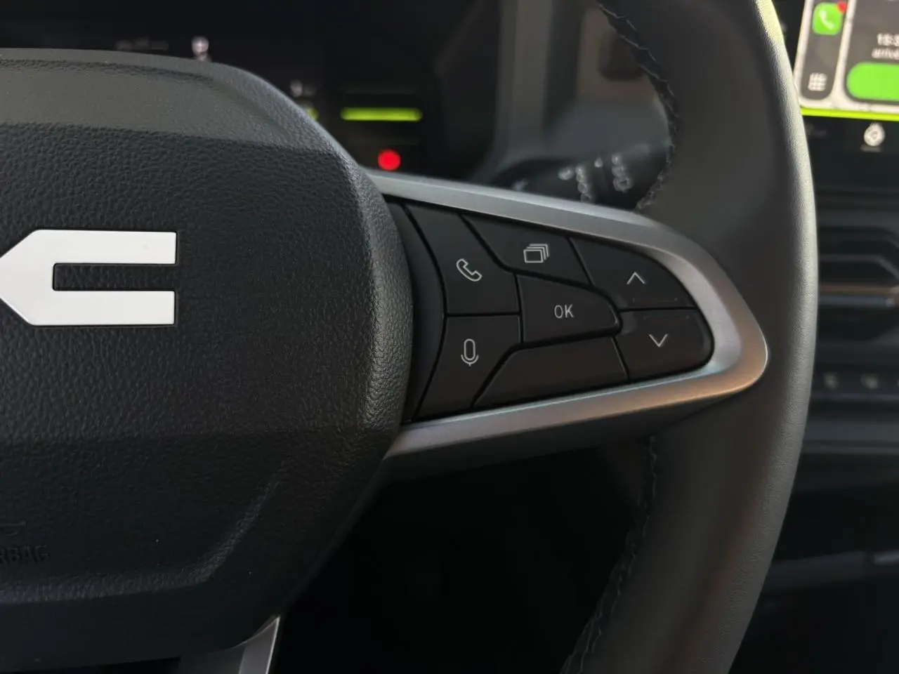 Gros plan sur les commandes au volant côté droit du Dacia Duster 2026, volant en cuir avec touches multifonctions.