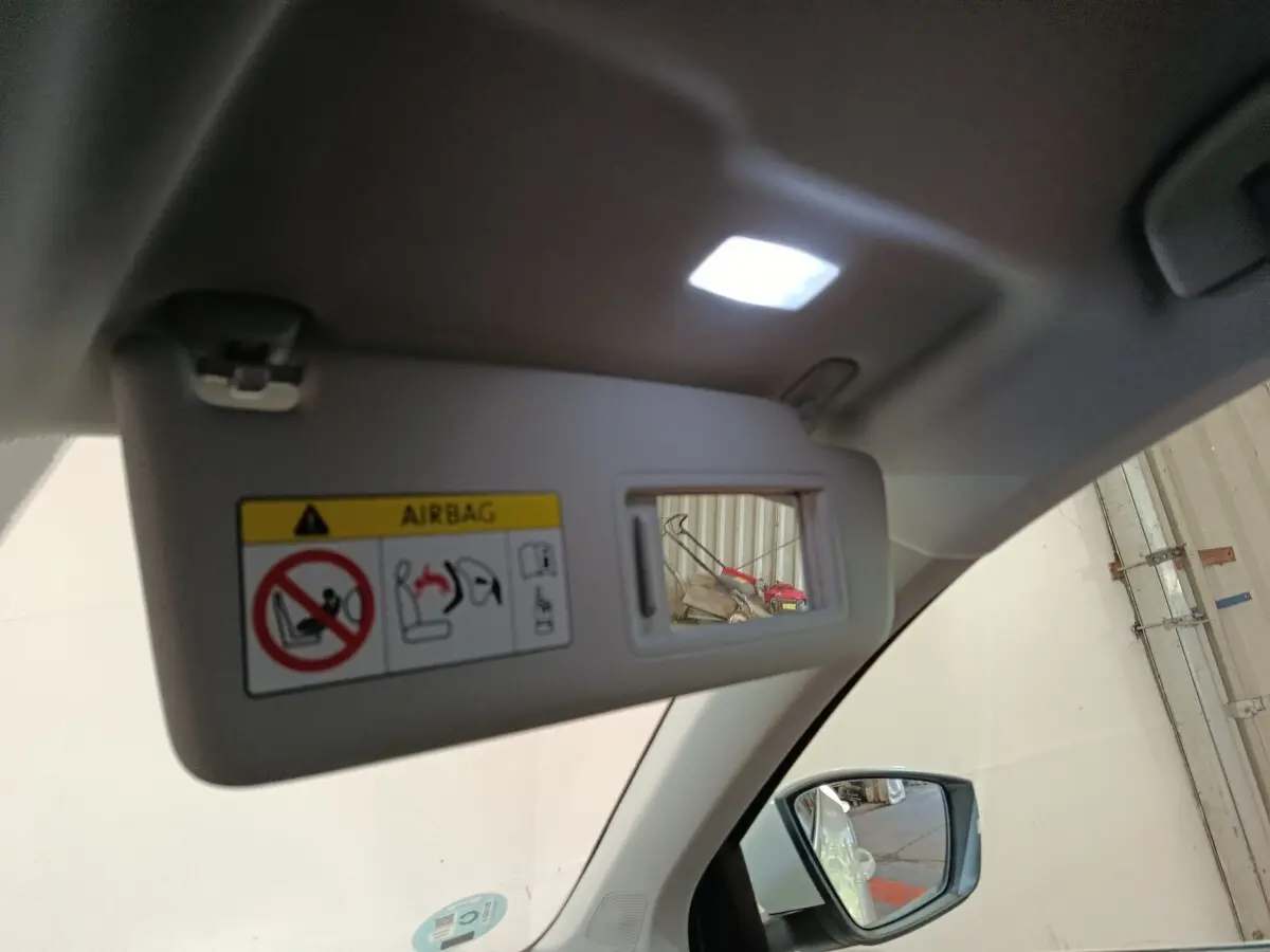 Miroir de courtoisie sur pare-soleil côté conducteur d’un Skoda Karoq blanc, intérieur clair avec rétroviseur visible.