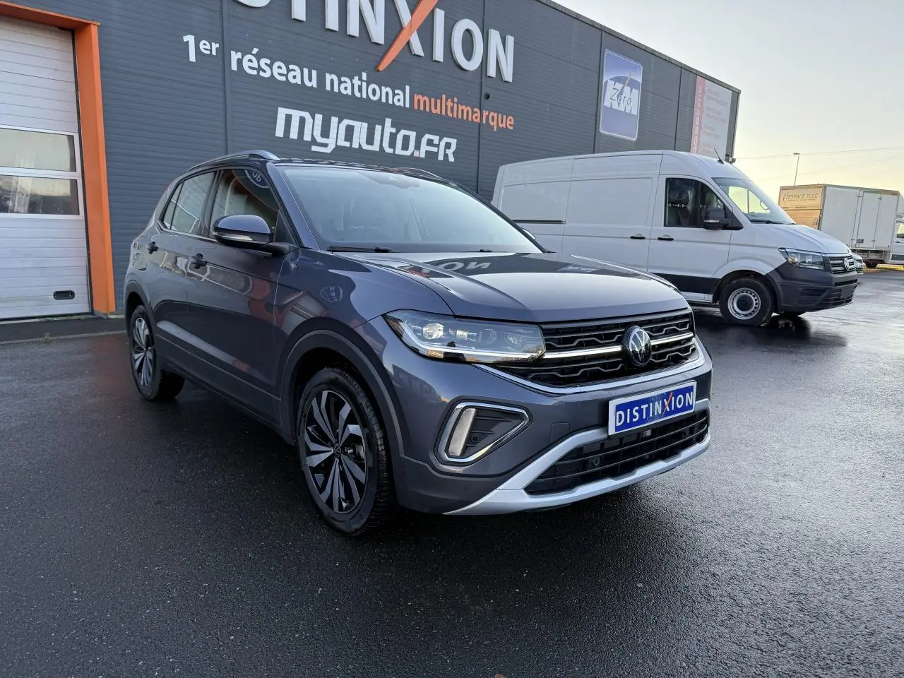 Volkswagen T-Cross gris cendre en 3/4 avant droit, avec calandre chromée et jantes alliage distinctives.