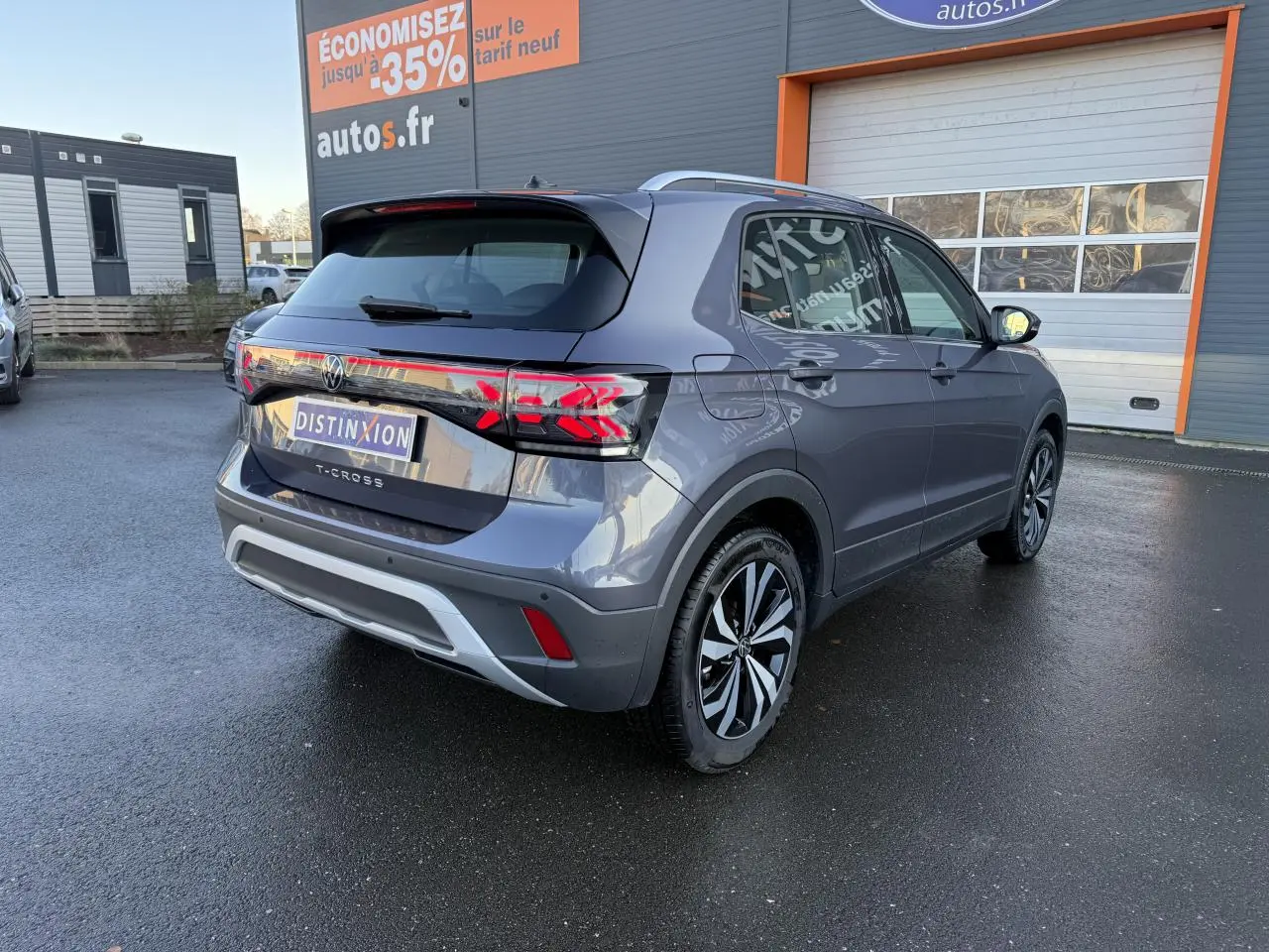 Volkswagen T-Cross gris cendre vu de l'arrière côté gauche, avec feux LED et jantes alliage distinctives.