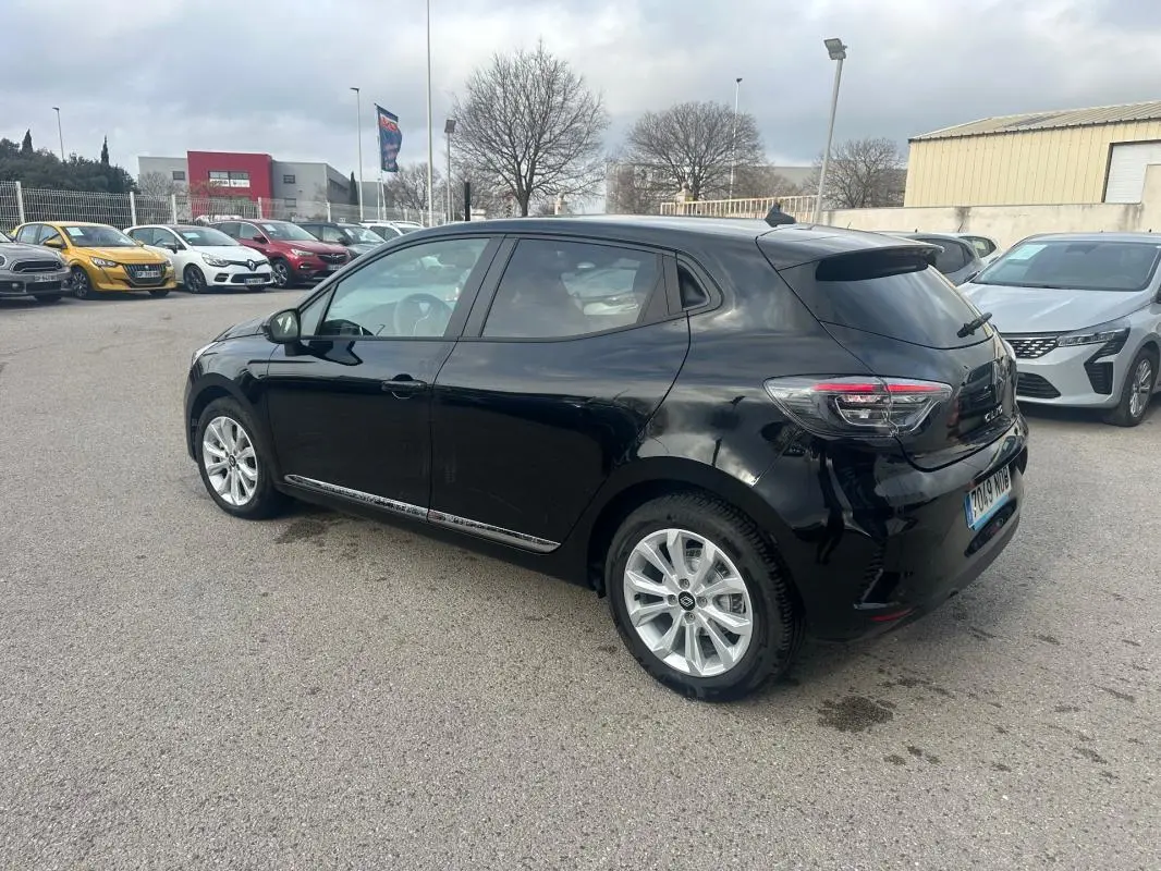 Renault Clio V dCi 100 Evolution noire vue en 3/4 arrière côté gauche, vitres surteintées et jantes argentées.