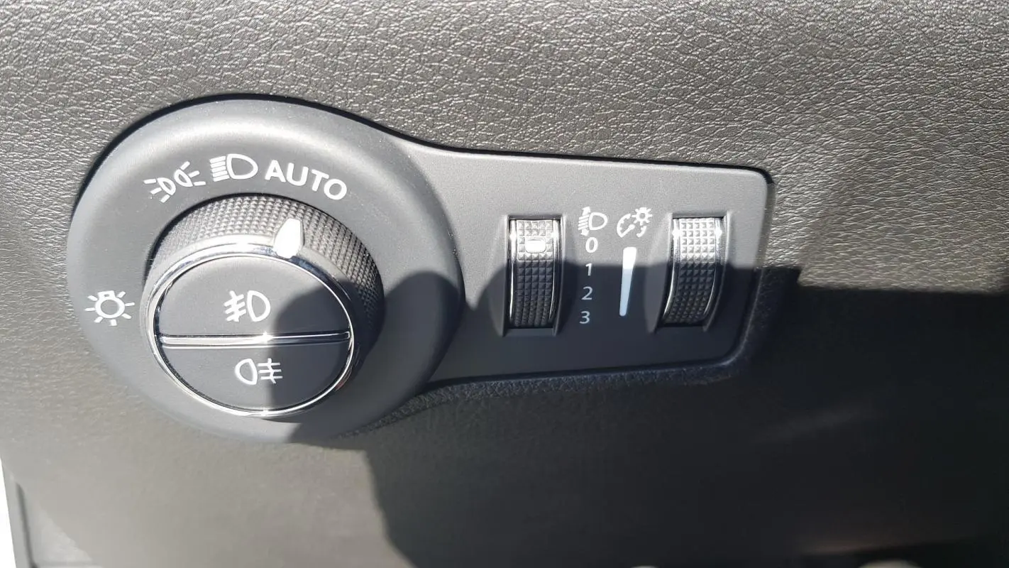 Gros plan sur le bouton de commande des phares et réglages d’éclairage du Jeep Compass blanc 2024.