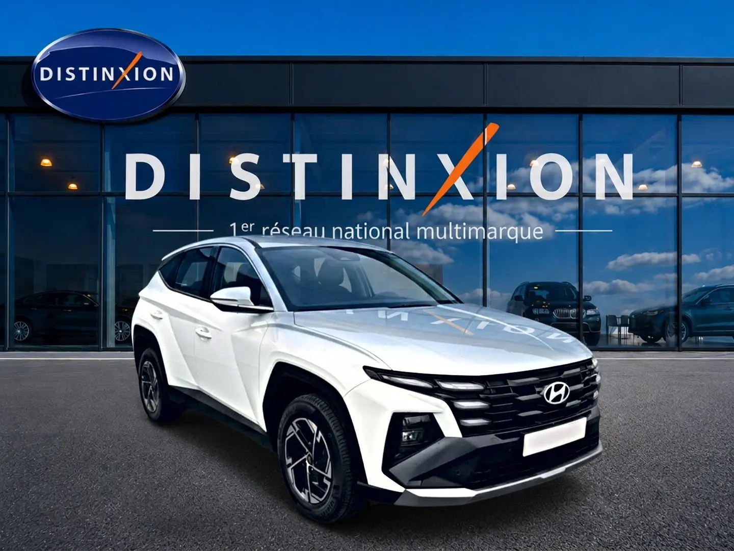 Hyundai Tucson blanc 2026 en 3/4 avant droit, avec calandre noire et jantes alliage 17 pouces visibles.