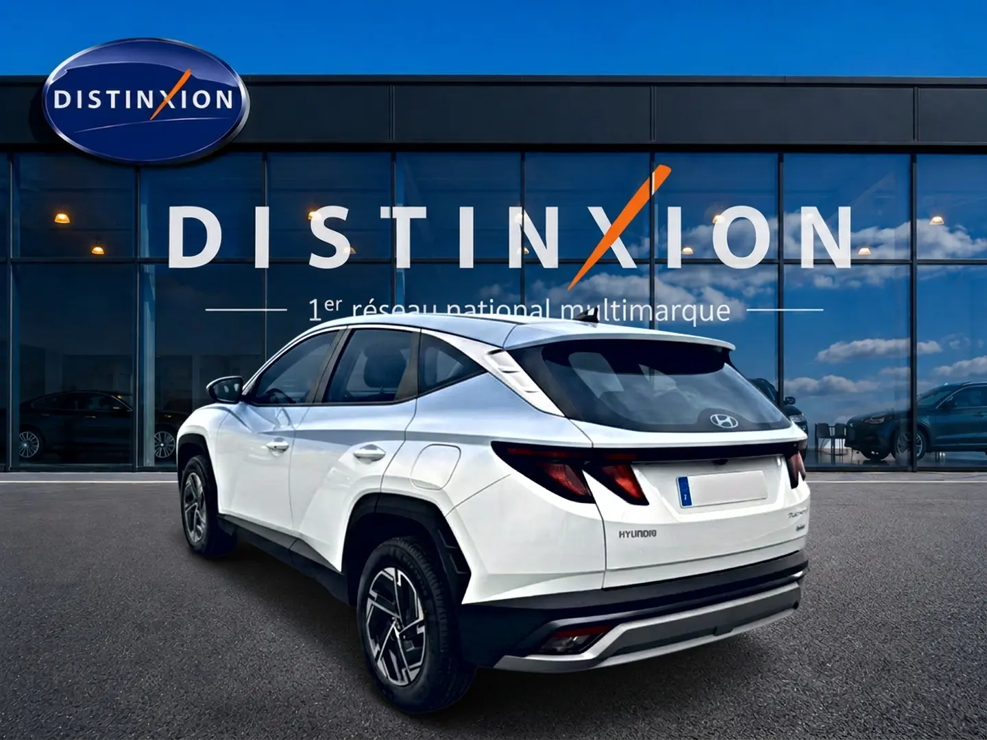 Vue 3/4 arrière droite du Hyundai Tucson blanc 2026 avec jantes alliage et feux arrière LED distinctifs.
