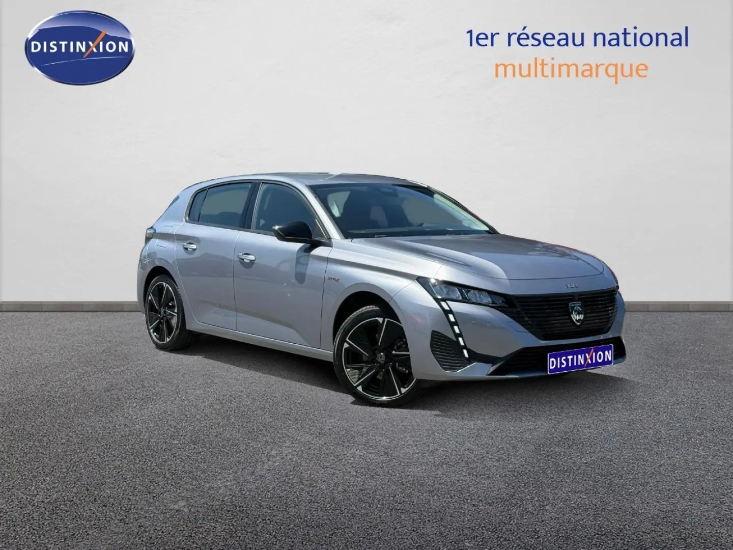 Peugeot e-308 gris Artense vue 3/4 avant droit, jantes alu noires et feux LED distinctifs.