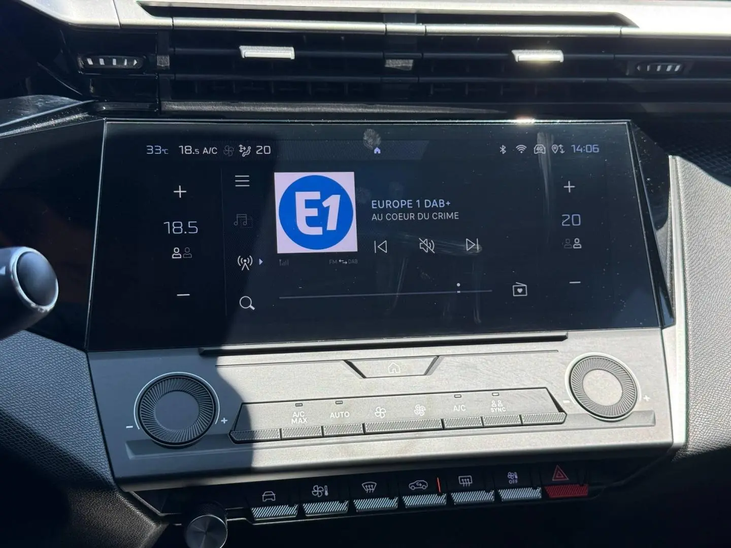 Vue rapprochée de l’écran tactile central et des commandes climatisation de la Peugeot 308 e-308 gris Artense.