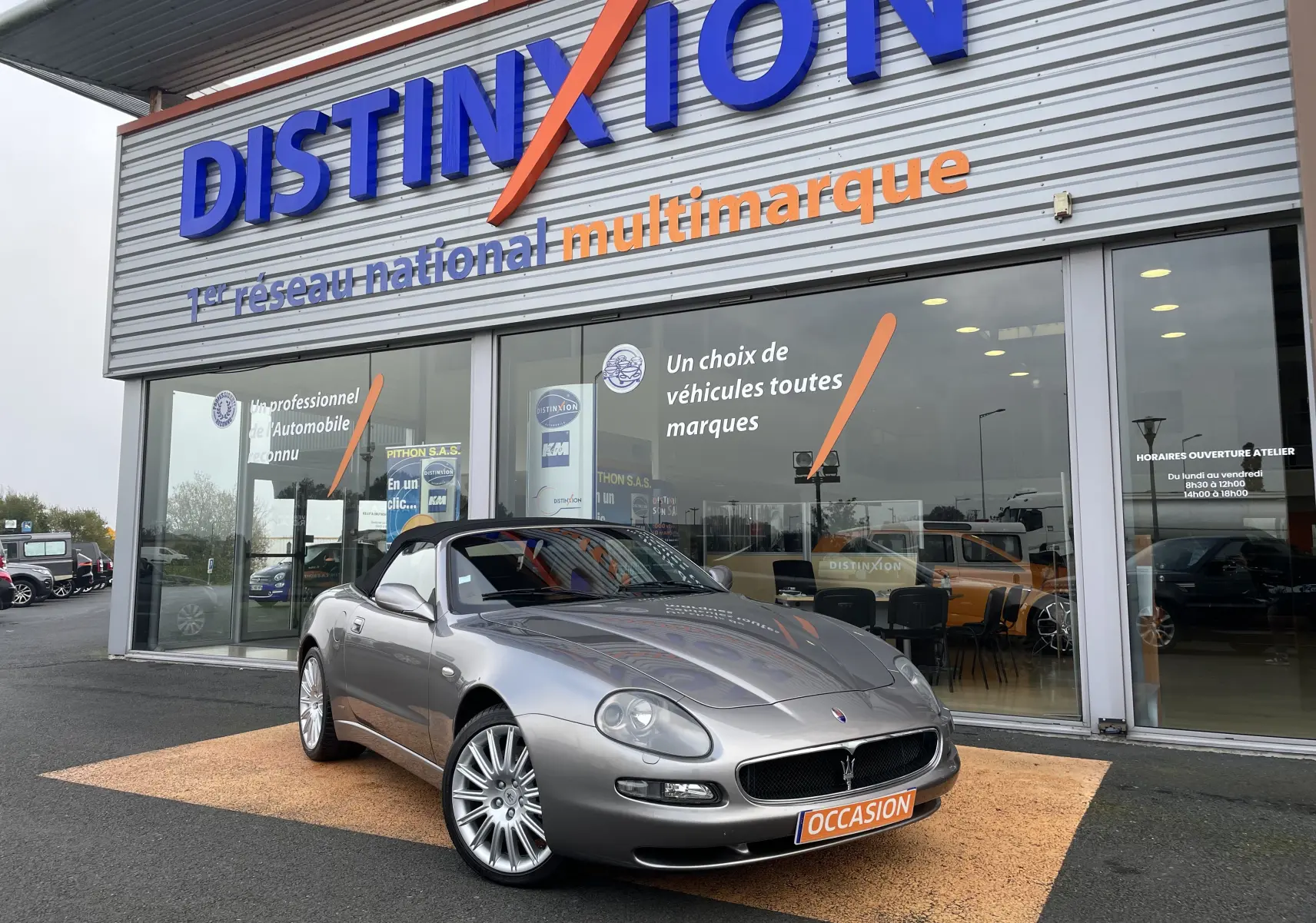 Maserati Spyder gris Nuvolari vue 3/4 avant droit, capote noire, jantes alliage et plaque occasion visible.