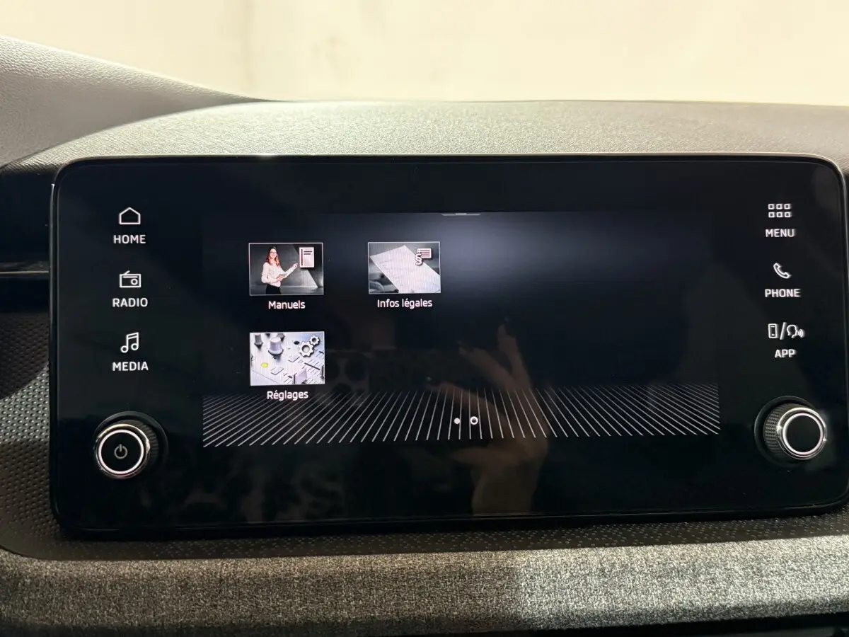 Écran tactile central du tableau de bord du Skoda Kamiq 2024 affichant les menus Réglages, Manuels et Infos légales.