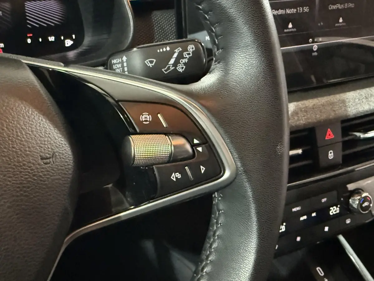 Gros plan sur le volant cuir côté gauche du Skoda Kamiq 2024 avec commandes multifonctions et tableau de bord digital.