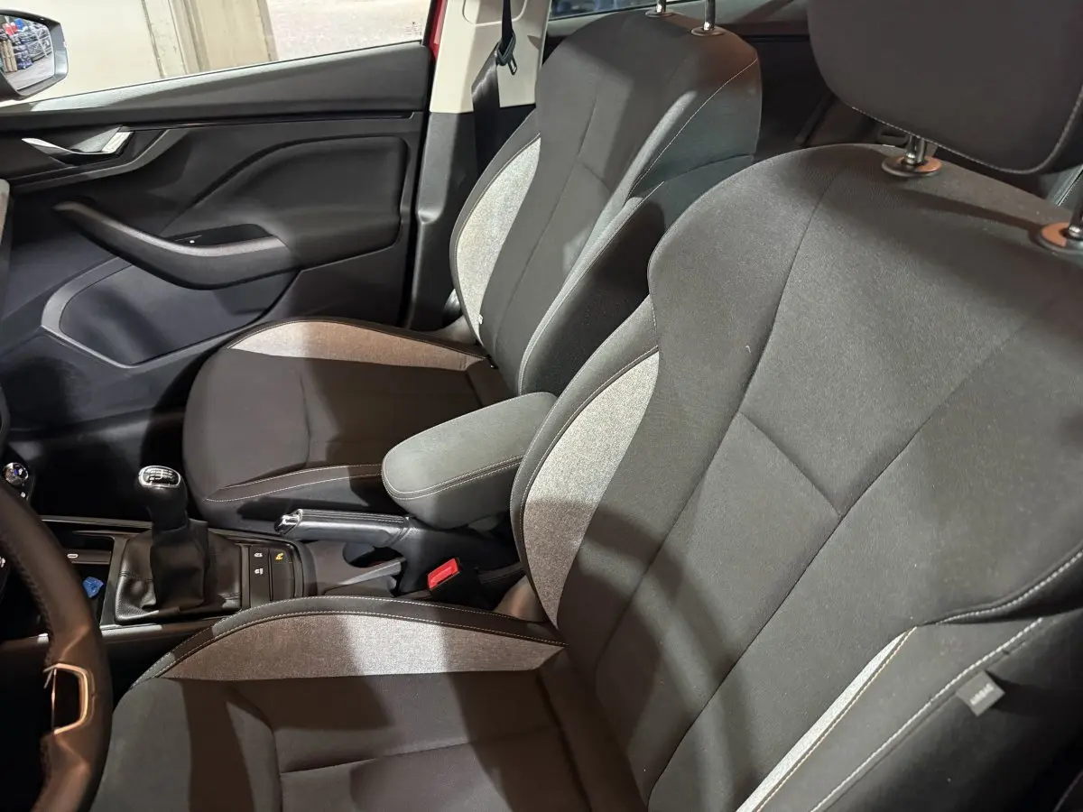 Vue intérieure côté gauche des sièges avant gris et noirs du Skoda Kamiq 2024 avec levier de vitesses manuel visible.