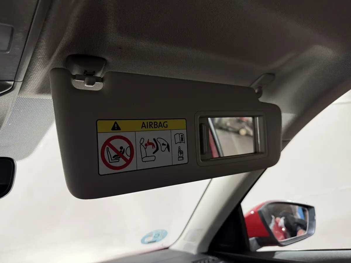 Miroir de courtoisie sur pare-soleil côté conducteur, avec rétroviseur extérieur rouge visible d'un Skoda Kamiq 2024.